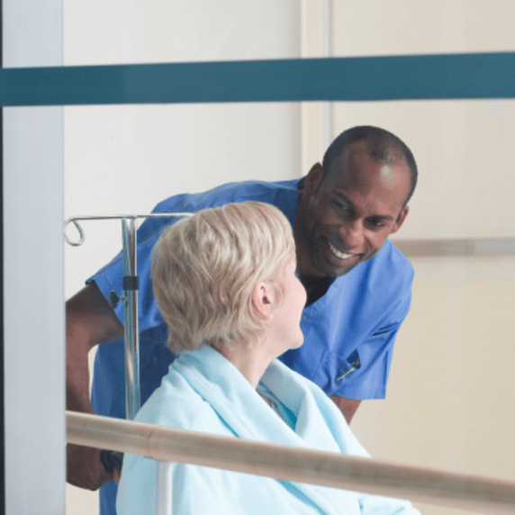 A male healthcare professional checking on a patient A male healthcare professional checking on a patient