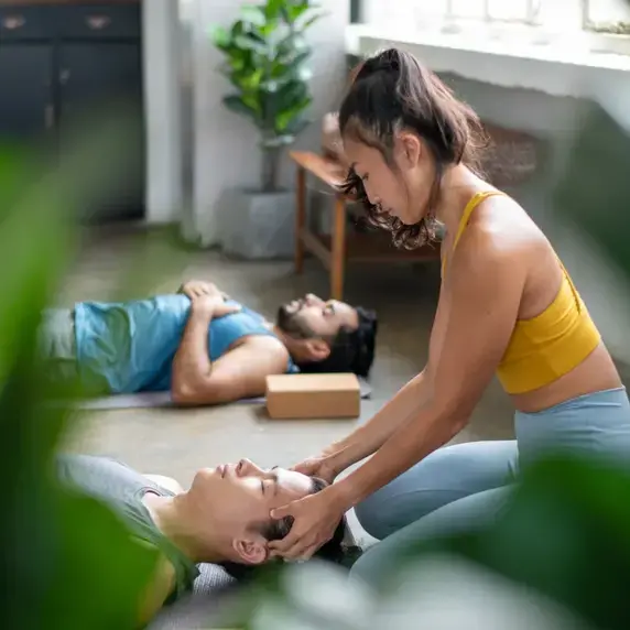 Yoga teacher guiding student Yoga teacher guiding student